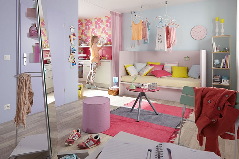 Chambre d'adolescent lumineuse avec lit, étagère, vêtements et accessoires