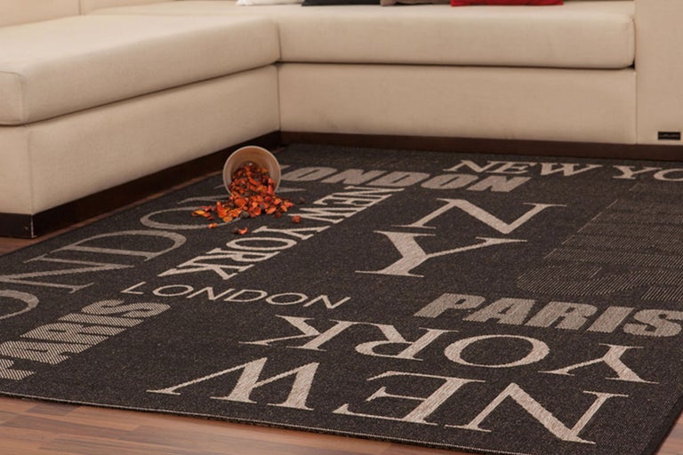 Tapis avec des noms de villes et canapé dans le salon