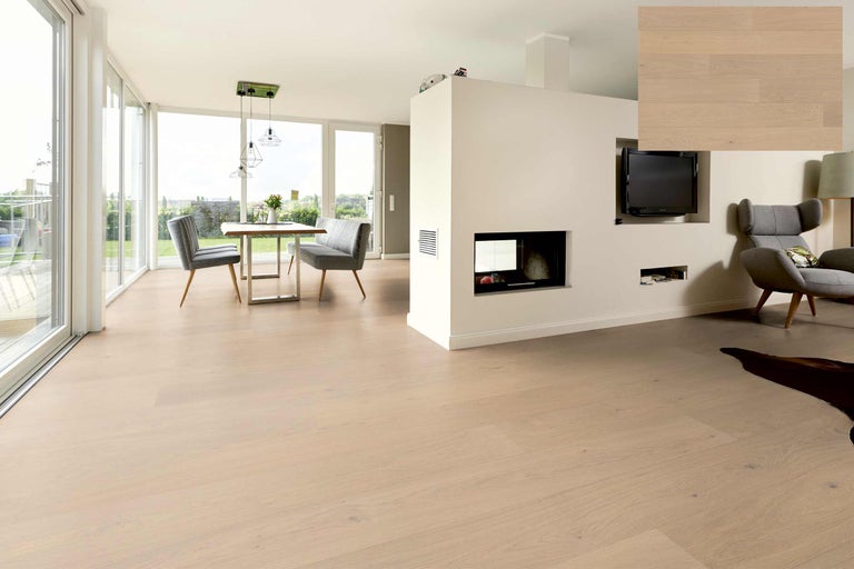 Heller Wohnraum mit Holzboden, Esstisch und Sitzecke.