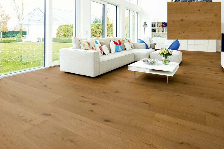 Heller Wohnraum mit Eichenparkettboden, Sofa und Gartenausblick