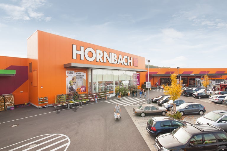 Vue extérieure d'un magasin de bricolage Hornbach avec parking et clients
