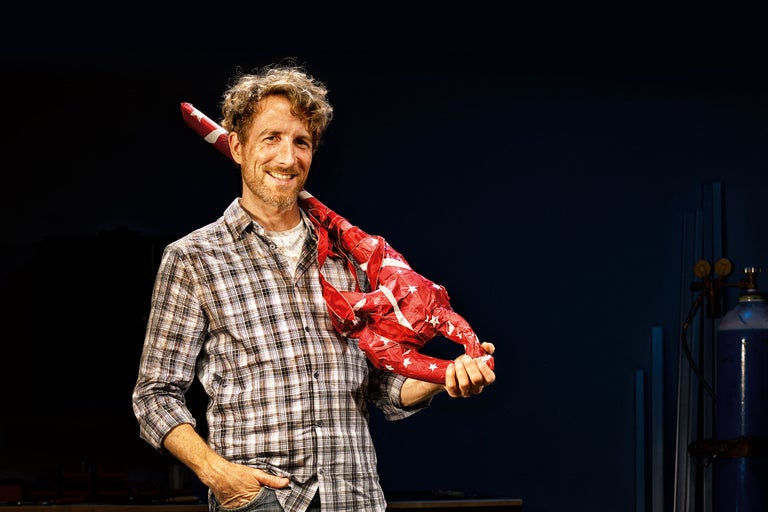 Homme avec une grande figure de crabe en papier avec motif étoilé sur l'épaule