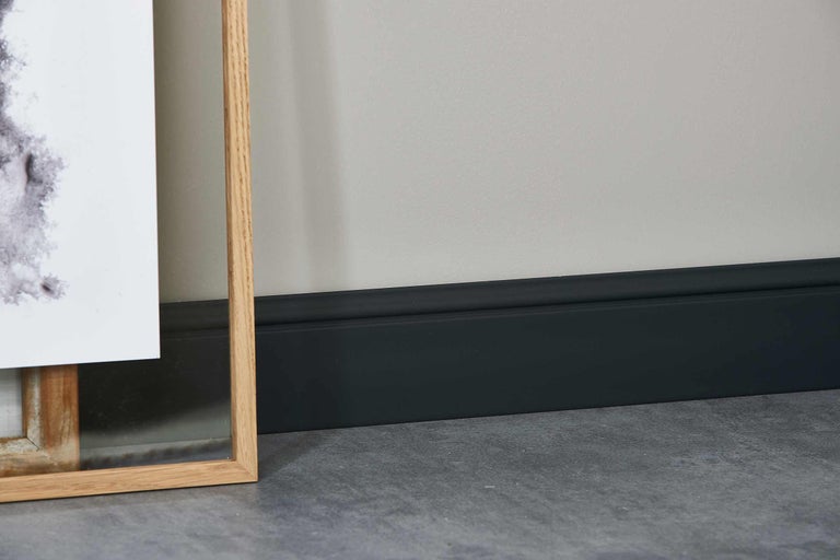 Gros plan d'une plinthe laquée foncée sur un mur