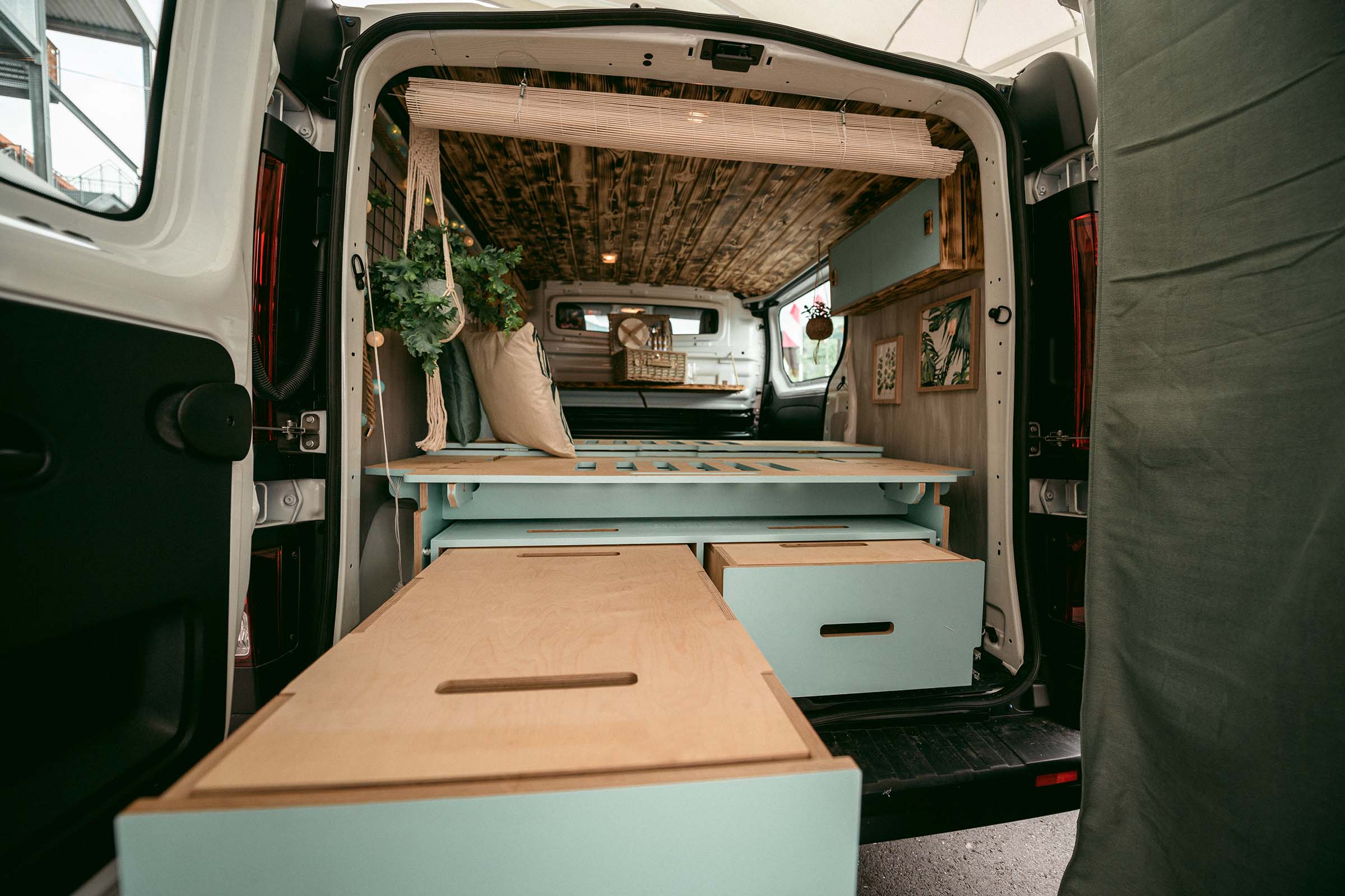 Intérieur d'un fourgon aménagé avec boiseries, lit et solutions de rangement