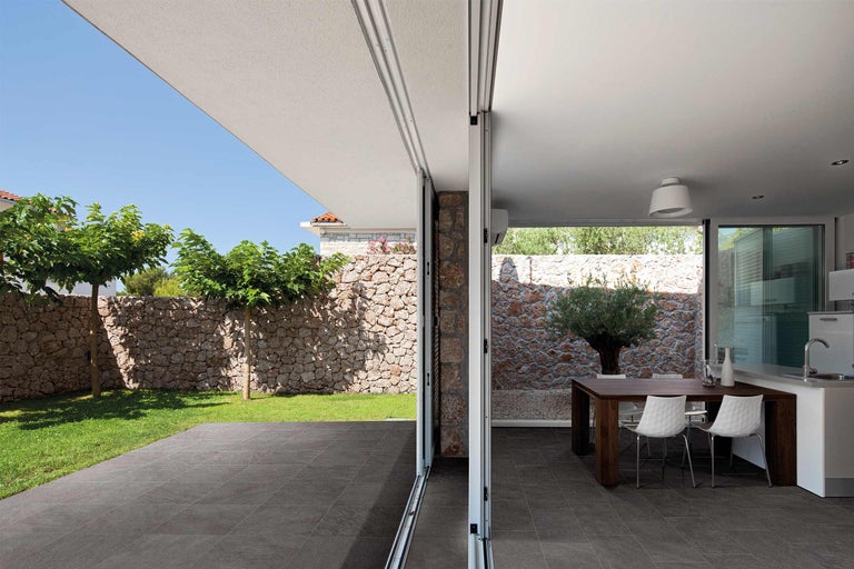 Helles Haus mit offenem Wohnbereich, Essbereich, Garten und Terrassenfliesen.