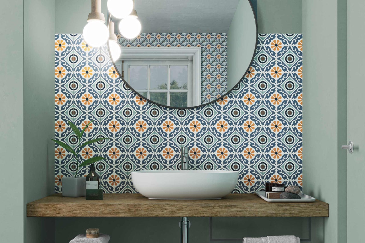 Salle de bain lumineuse avec lavabo, miroir et carrelage à motifs