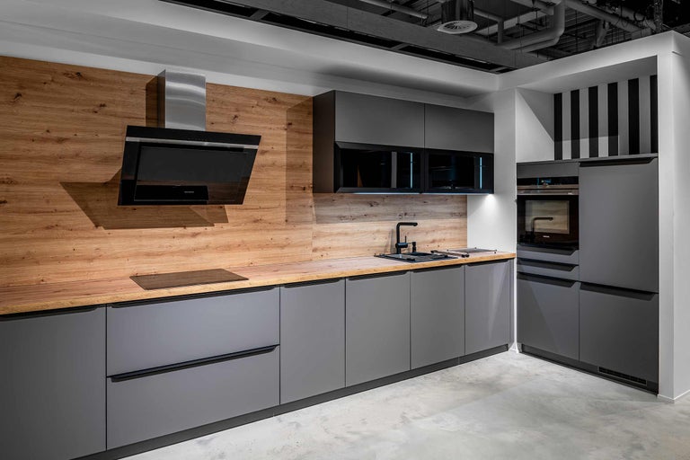 Cuisine moderne avec armoires grises, plan de travail en bois et appareils Siemens.