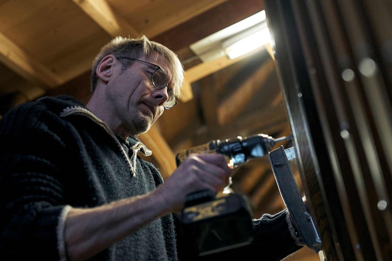 Handwerker bohrt mit Akkubohrer in Metallprofil