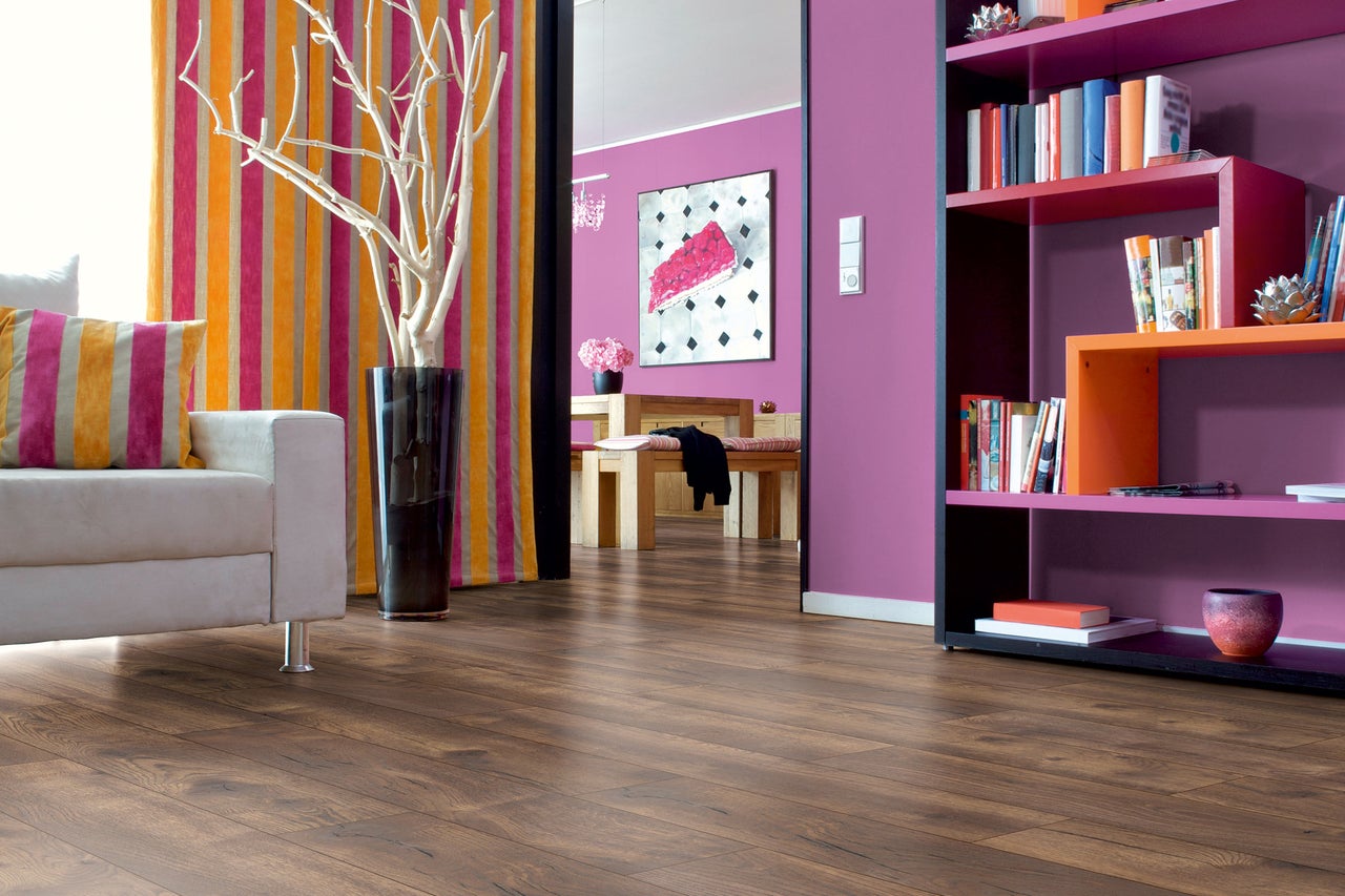 Wohnzimmer mit Laminatboden, Sofa, Vorhängen und Bücherregal für ein modernes Wohnambiente