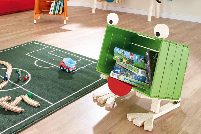 Chambre d'enfant avec coffre à jouets vert en forme de grenouille, tapis de jeu et jouets