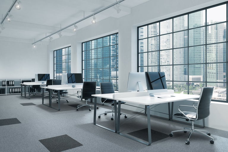 Bureau lumineux avec bureaux, chaises de bureau et vue sur la ville