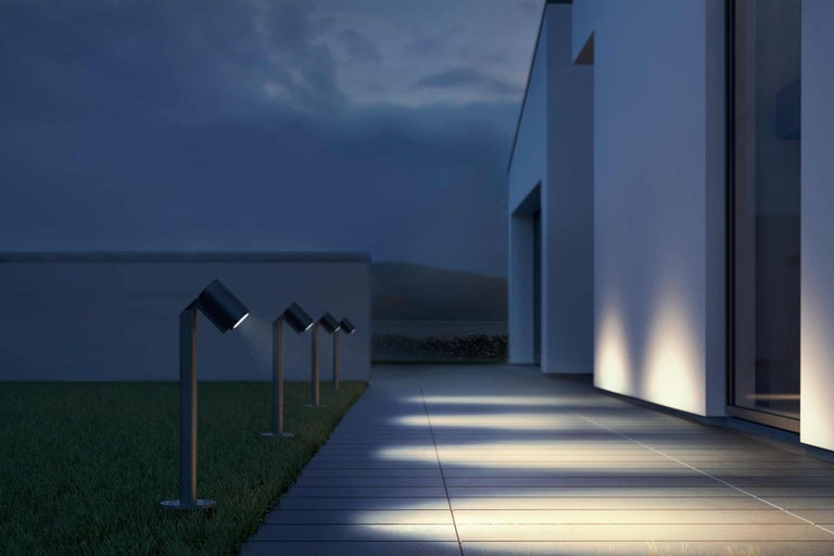 Aussenbereich mit Rasenfläche, Terrasse und Gartenleuchten zur Beleuchtung des Weges an einem Gebäude
