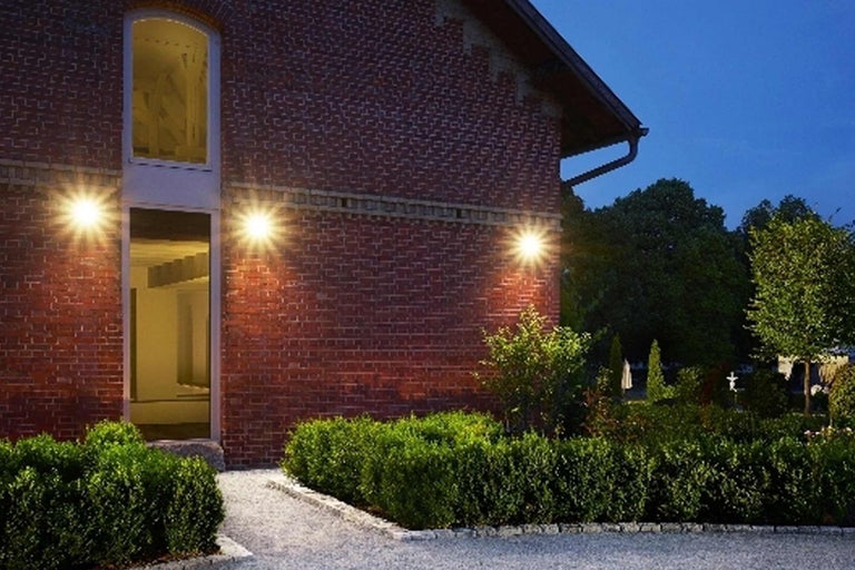 Aussenansicht eines Backsteingebäudes mit Gartenbeleuchtung