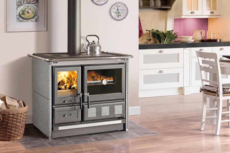 Scène de cuisine avec cuisinière à bois, ustensiles de cuisine et aliments sur un plan de travail