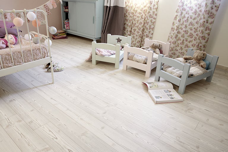 Salle de jeux pour enfants avec plancher en bois, lits de poupées et jouets