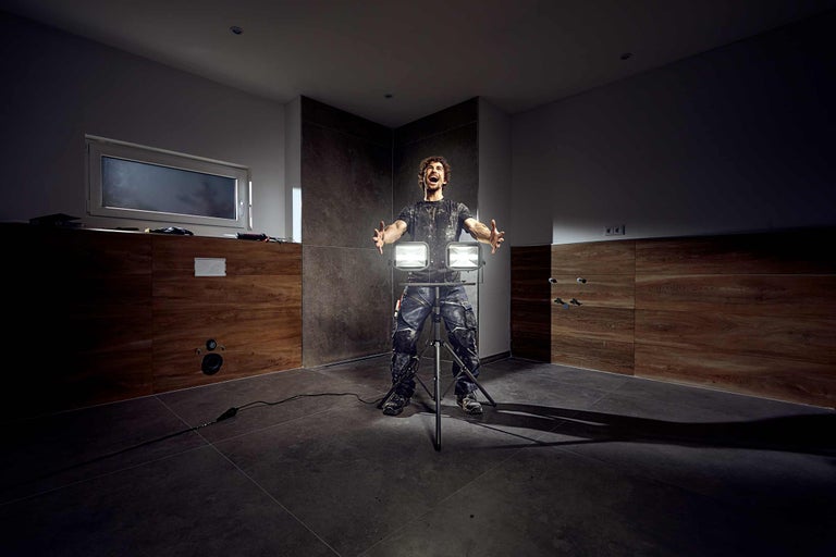 Handwerker mit Arbeitsleuchte in einem Badezimmer im Bau