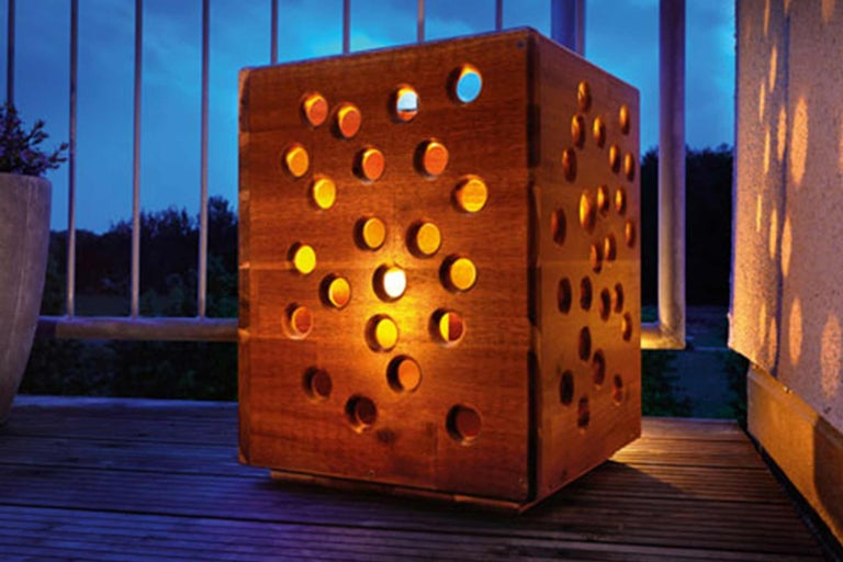 Lanterne décorative en bois avec des découpes rondes pour l'extérieur.