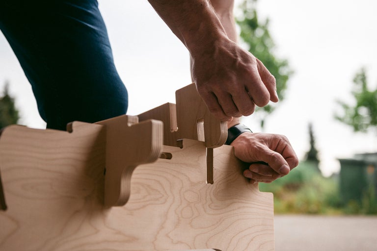Person montiert eine Holzkonstruktion im Aussenbereich