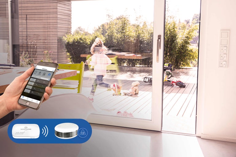 Commande Smart Home avec application et capteurs dans un espace de vie avec enfant sur la terrasse