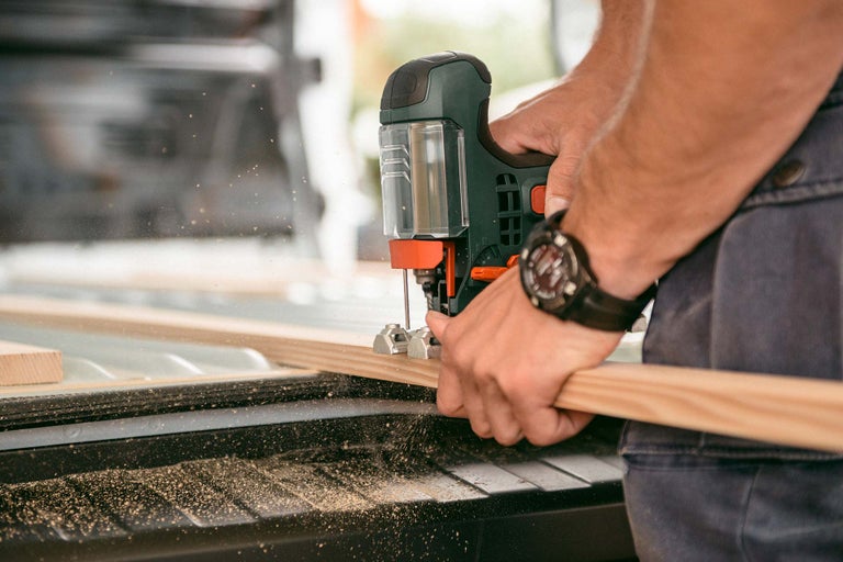Handwerker sägt Holz mit einer Stichsäge.