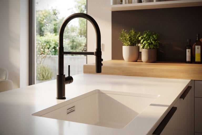 Évier de cuisine moderne avec robinet haut intégré dans une cuisine lumineuse avec plan de travail en bois et plantes.
