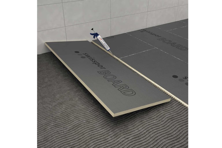 Montage de panneaux de construction Swissspor Board avec de la colle de montage sur un support.