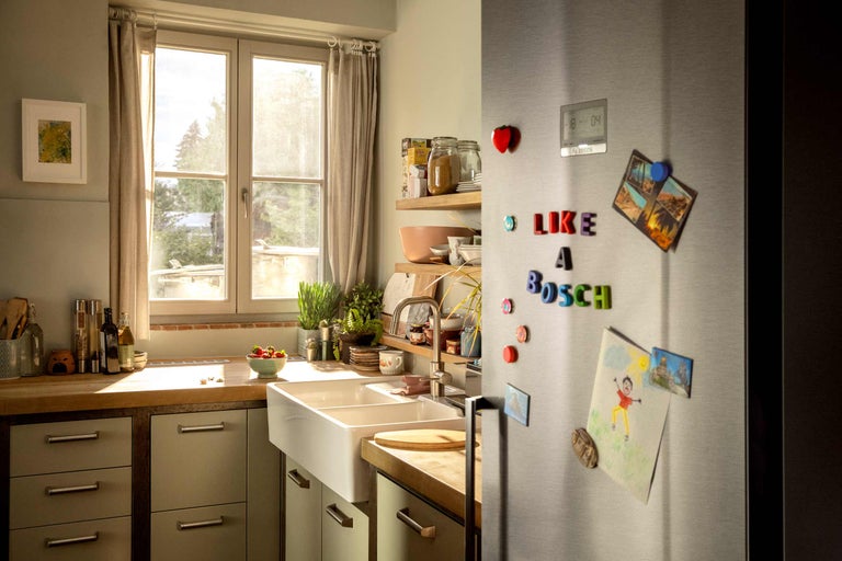 Cuisine lumineuse avec double évier, plan de travail en bois et réfrigérateur Bosch