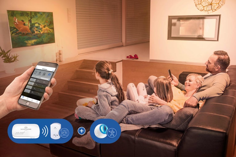 Famille se détendant dans le salon avec la commande Smart Home via l'application