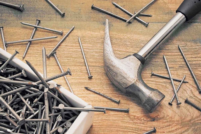 Hammer und Nägel auf einer Holzoberfläche