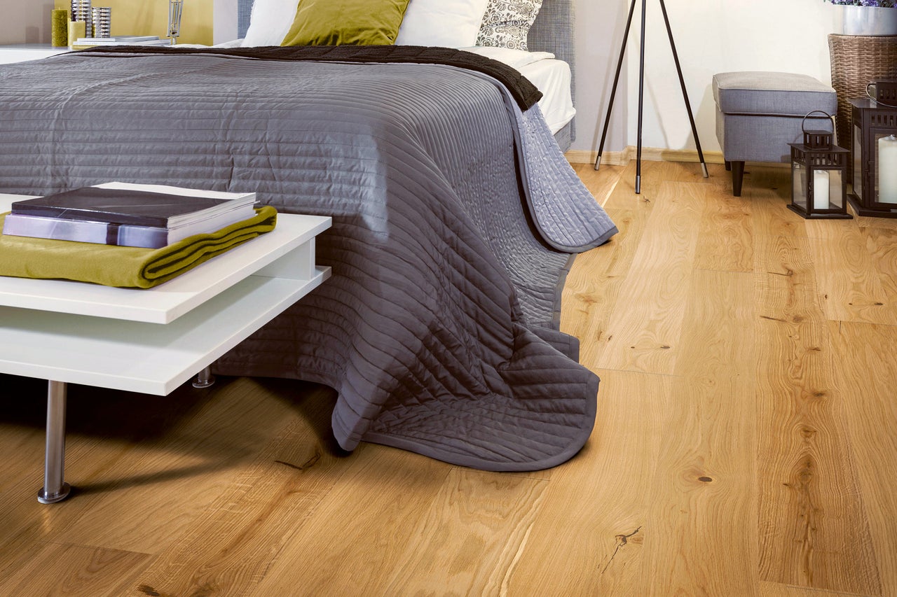Schlafzimmer mit Holzboden, Bett und Nachttisch