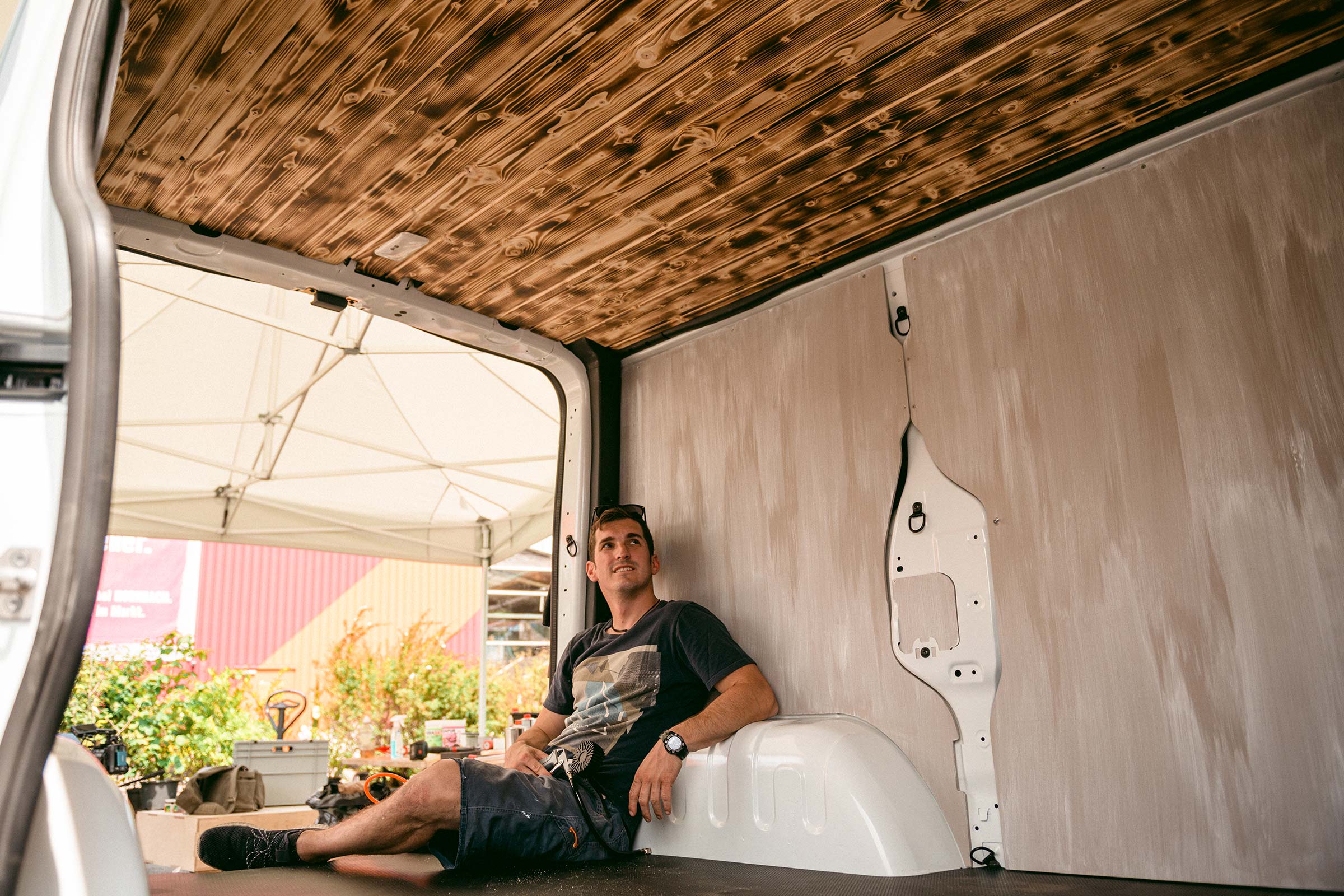 Intérieur d'un van avec plafond en bois et homme