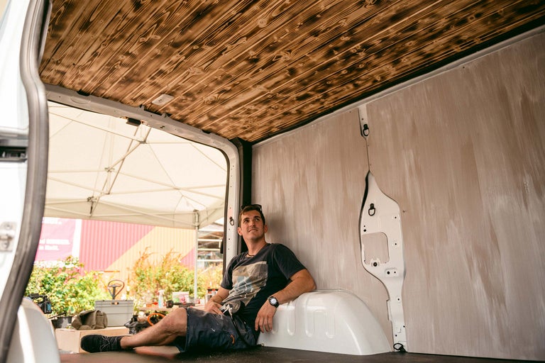 Innenraum eines Lieferwagens mit Holzdecke und Mann