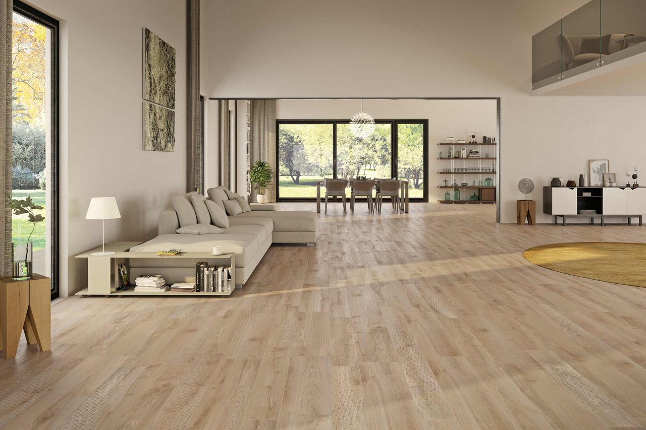 Salon lumineux avec plancher en bois, canapé et coin repas