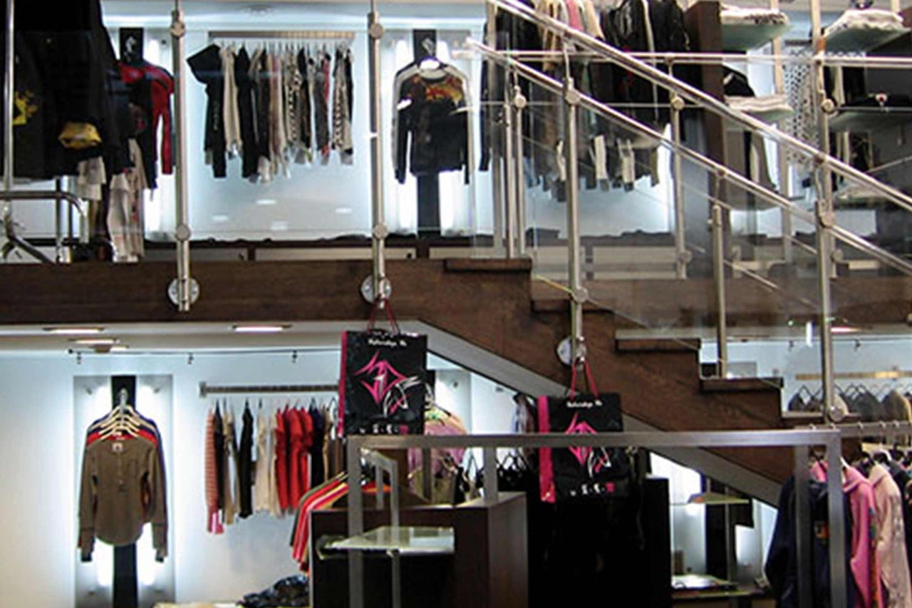 Bekleidungsgeschäft mit Kleidung auf Kleiderbügeln und Treppe