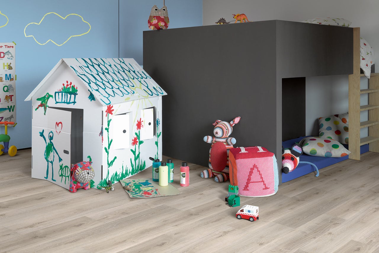 Kinderspielzimmer mit bemalter Spielhütte, Kinderbett und Spielzeug