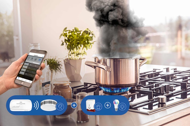 Système Smart Home Détecteur de fumée en action avec dégagement de fumée sur la cuisinière