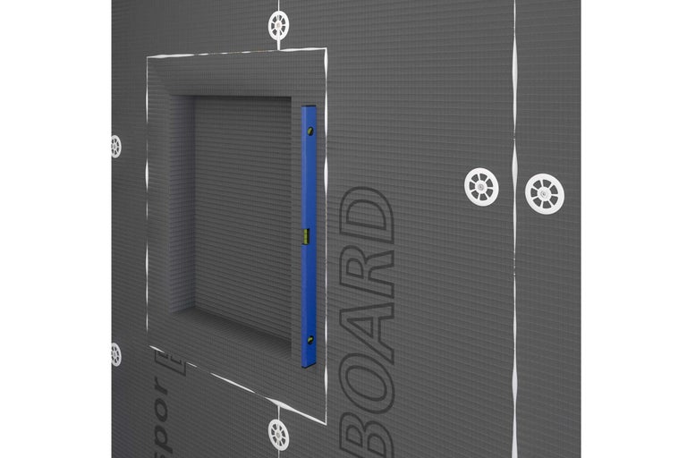 Installation d'une salle de bains avec des panneaux de construction et un niveau à bulle