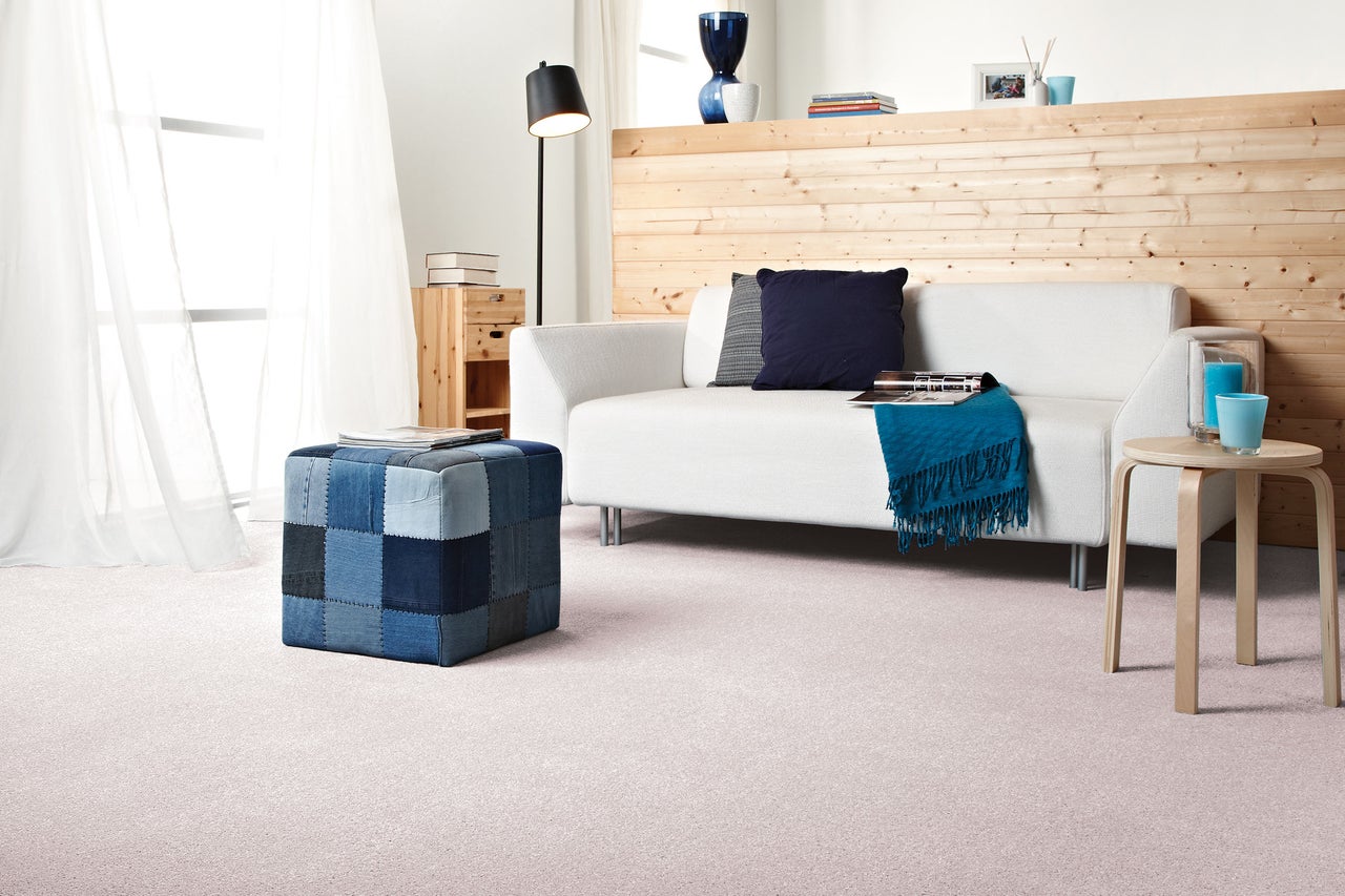 Wohnzimmer mit Sofa, Hocker und Teppich