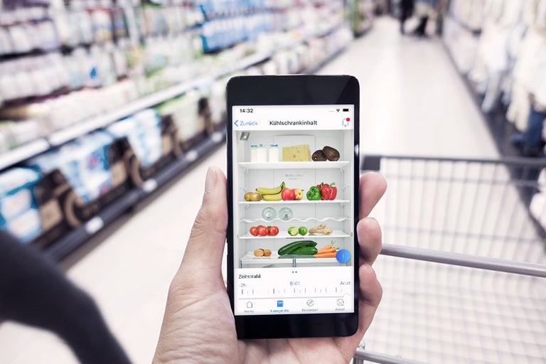 Smartphone mit App zur Kühlschrankinhaltskontrolle im Supermarkt