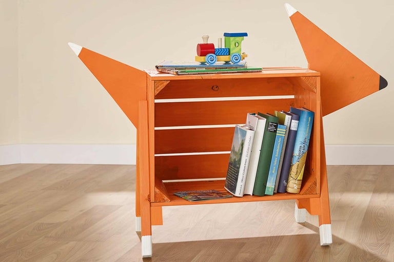 Étagère en bois en forme de renard avec des livres et des jouets