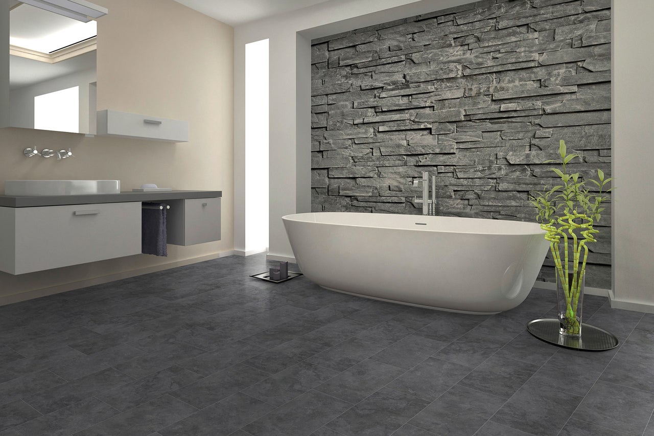 Modernes Badezimmer mit freistehender Badewanne, Waschtisch und Steinwand