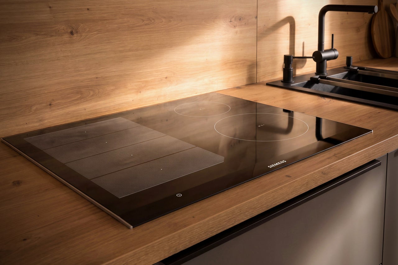 Siemens Induktionskochfeld mit FlexInduction in einer modernen Holzküchenzeile mit dunkler Spüle.