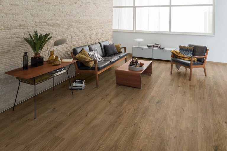 Wohnzimmer mit Bodenbelag in Holzoptik, Sofa und Sessel
