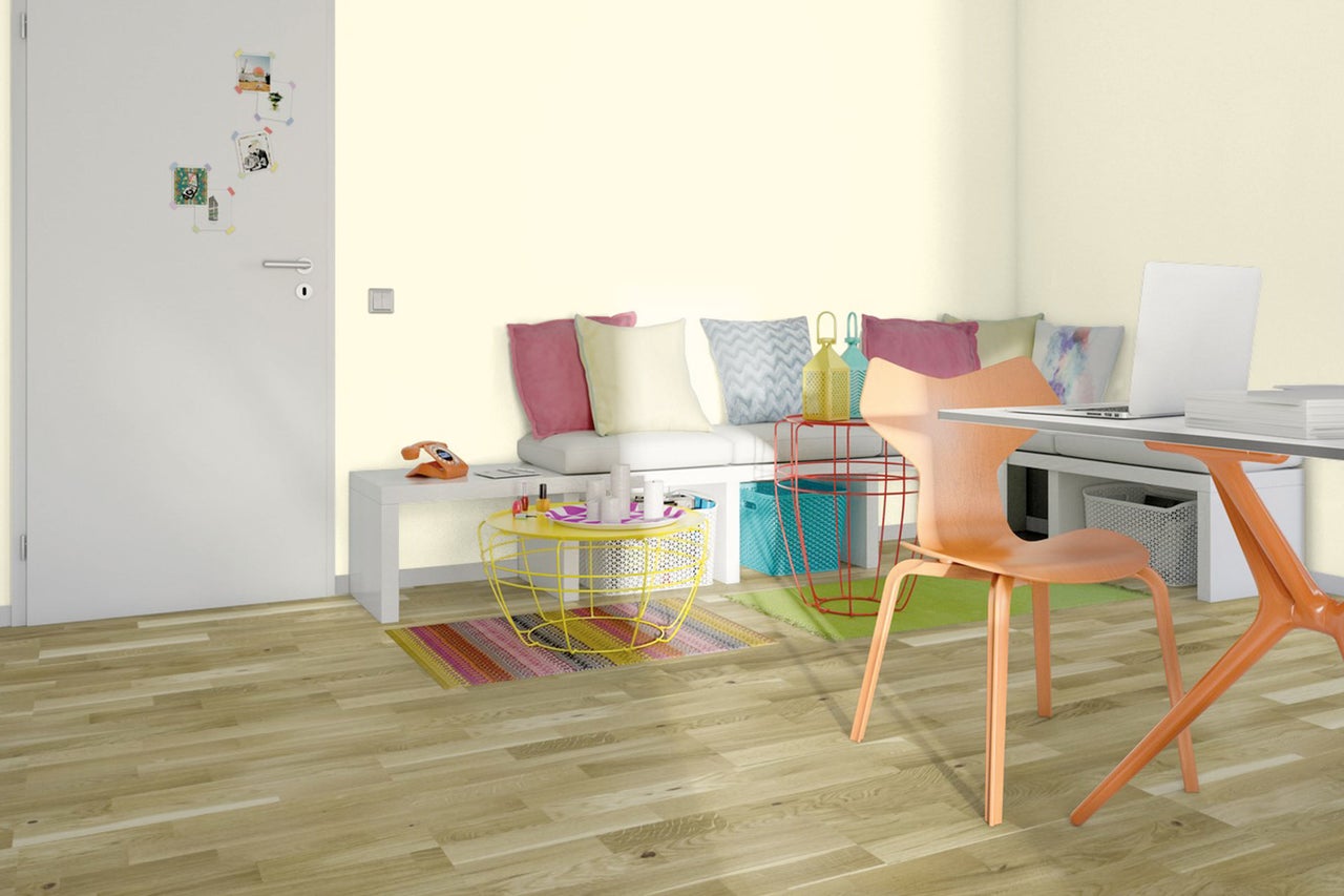 Heller Wohnraum mit Holzboden, Sitzgelegenheit mit Kissen, Tisch und Stuhl.