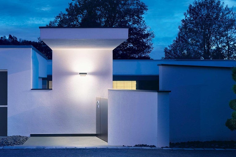 Beleuchtete Hausfassade mit moderner Aussenleuchte.