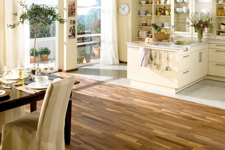 Heller Wohnraum mit Holzboden, Esstisch und Küchenzeile