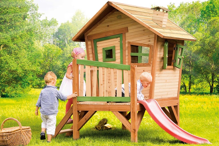 Cabane de jeu en bois avec toboggan dans le jardin avec des enfants qui jouent