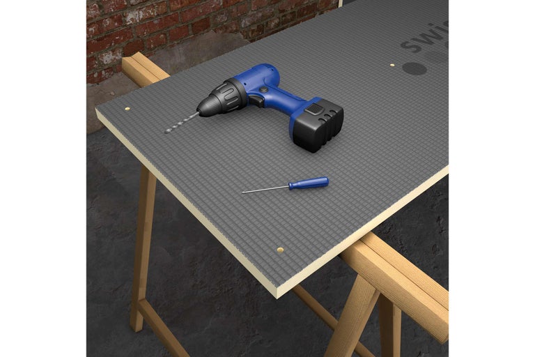 Image d'une plaque de construction avec perceuse et tournevis sur une structure en bois.