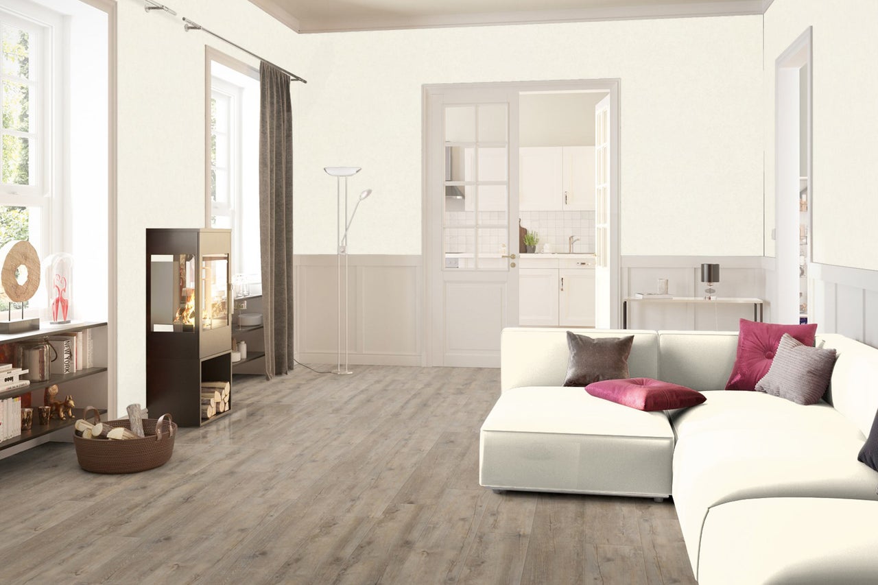 Heller Wohnraum mit Sofa, Kaminofen und Holzboden