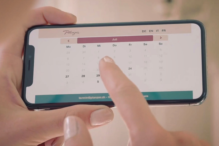 Ein Mobiltelefon zeigt die Kalender-App im Monat Juli.